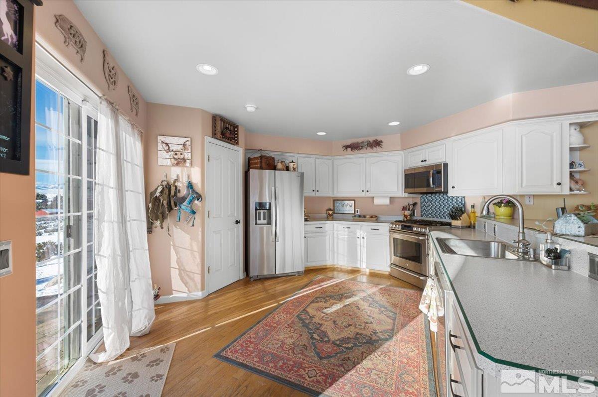 12803 North Red Rock Road Reno, NV 89508 - Photo 11 of 40 a kitchen with stainless steel appliances granite countertop a refrigerator and a stove top oven