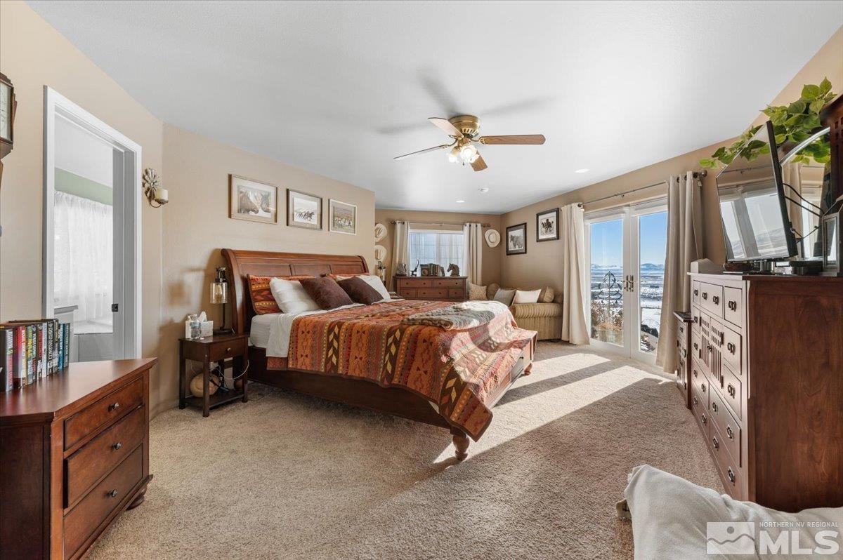 12803 North Red Rock Road Reno, NV 89508 - Photo 13 of 40 a bedroom with a large bed and a chandelier
