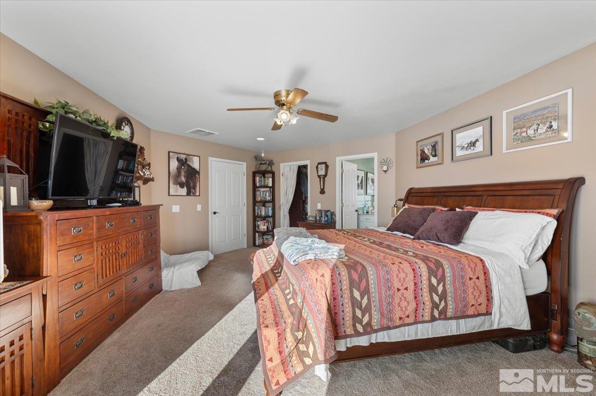 12803 North Red Rock Road Reno, NV 89508 - Photo 15 of 40 a spacious bedroom with a bed and a flat screen tv
