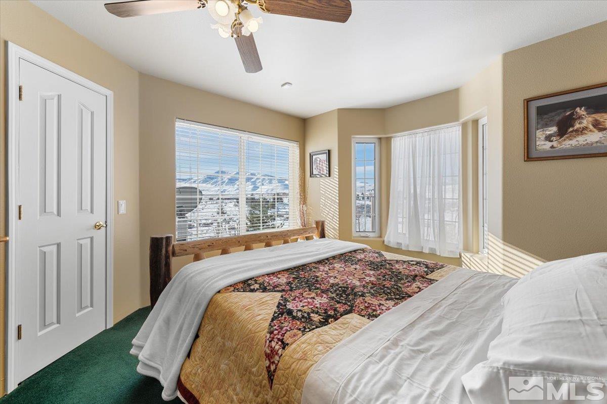 12803 North Red Rock Road Reno, NV 89508 - Photo 20 of 40 a bedroom with a large bed and a chandelier