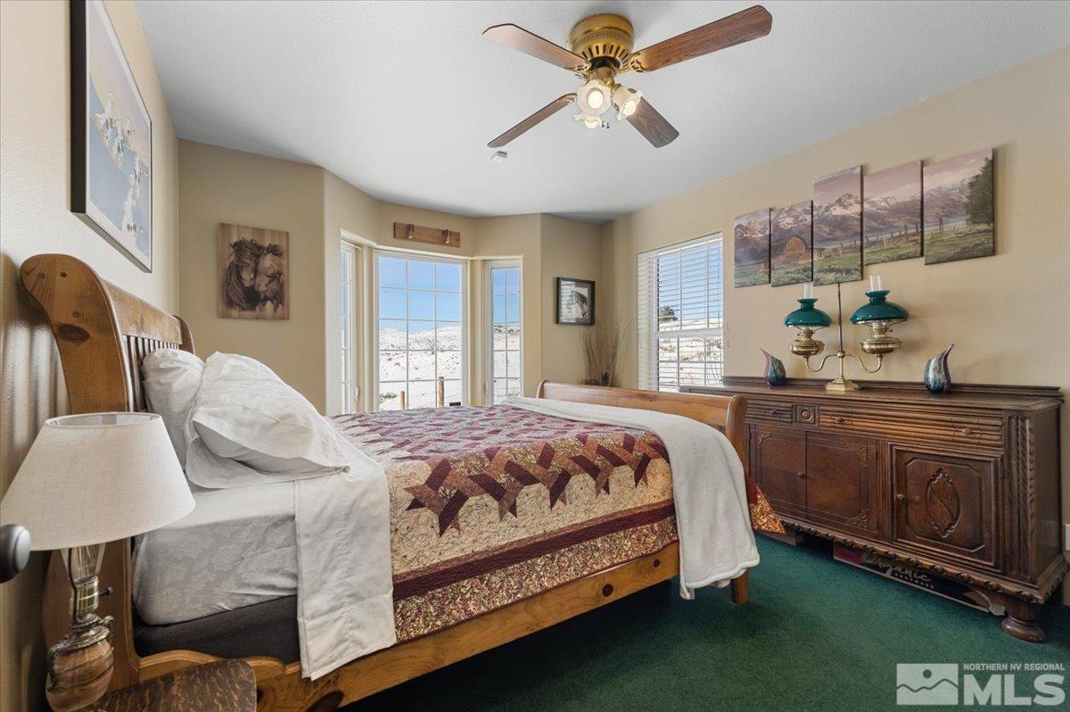 12803 North Red Rock Road Reno, NV 89508 - Photo 21 of 40 a bedroom with a bed chandelier and window