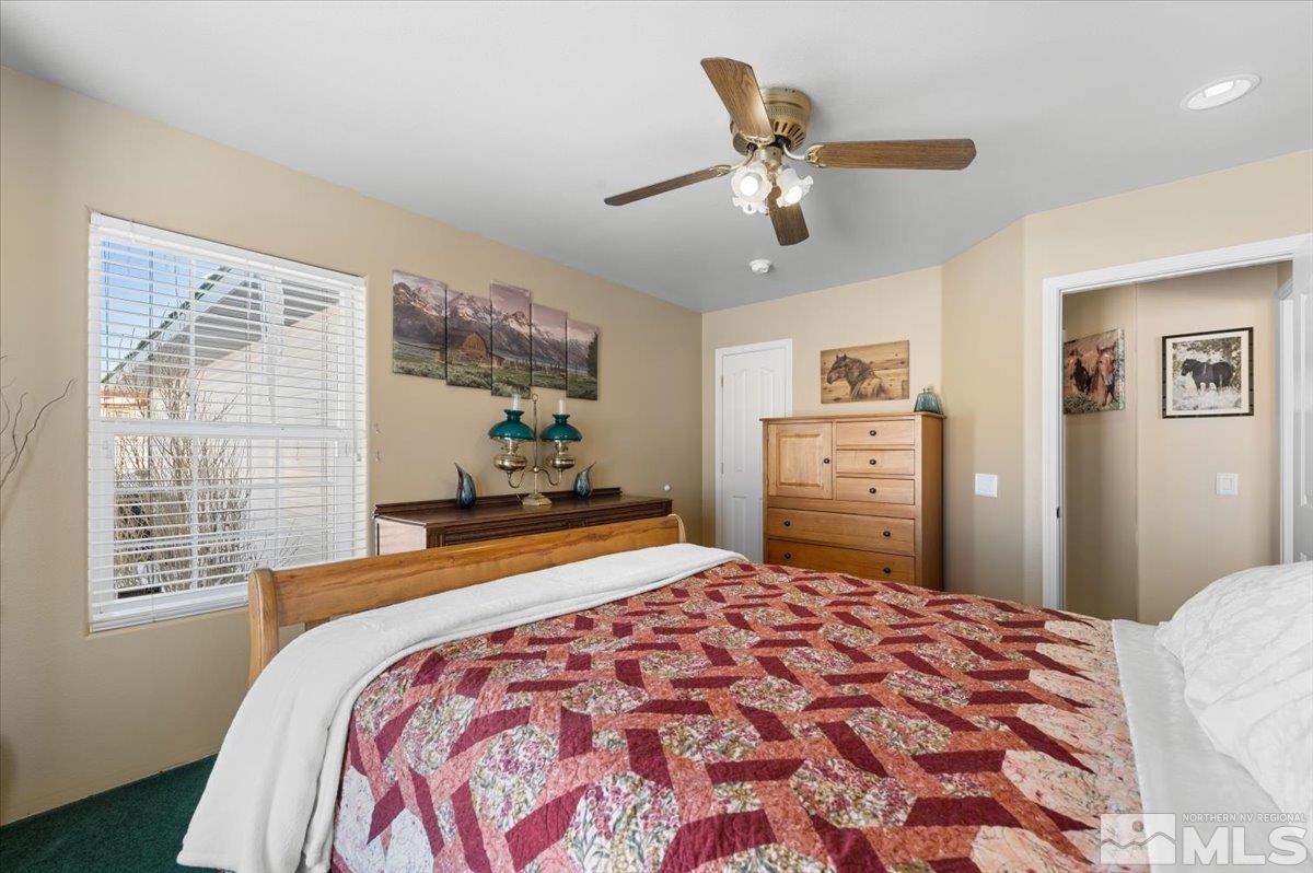 12803 North Red Rock Road Reno, NV 89508 - Photo 22 of 40 a bedroom with a large bed and a chandelier