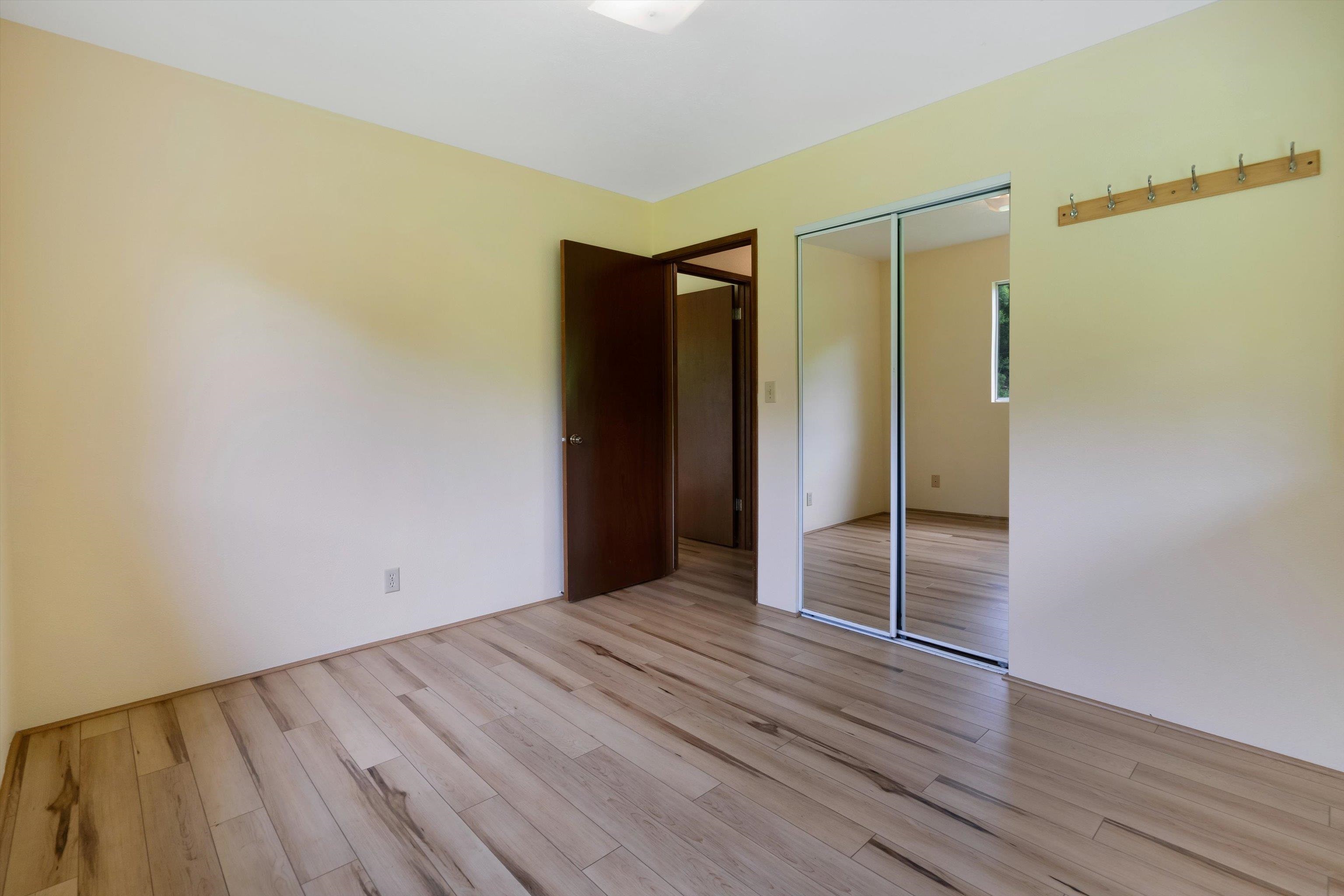 1784 West Kuiaha Road Haiku, HI 96708 - Photo 13 of 27 a view of an empty room with wooden floor and a window