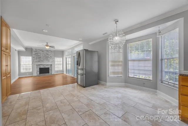 a large kitchen with granite countertop a stove a sink a counter space and cabinets