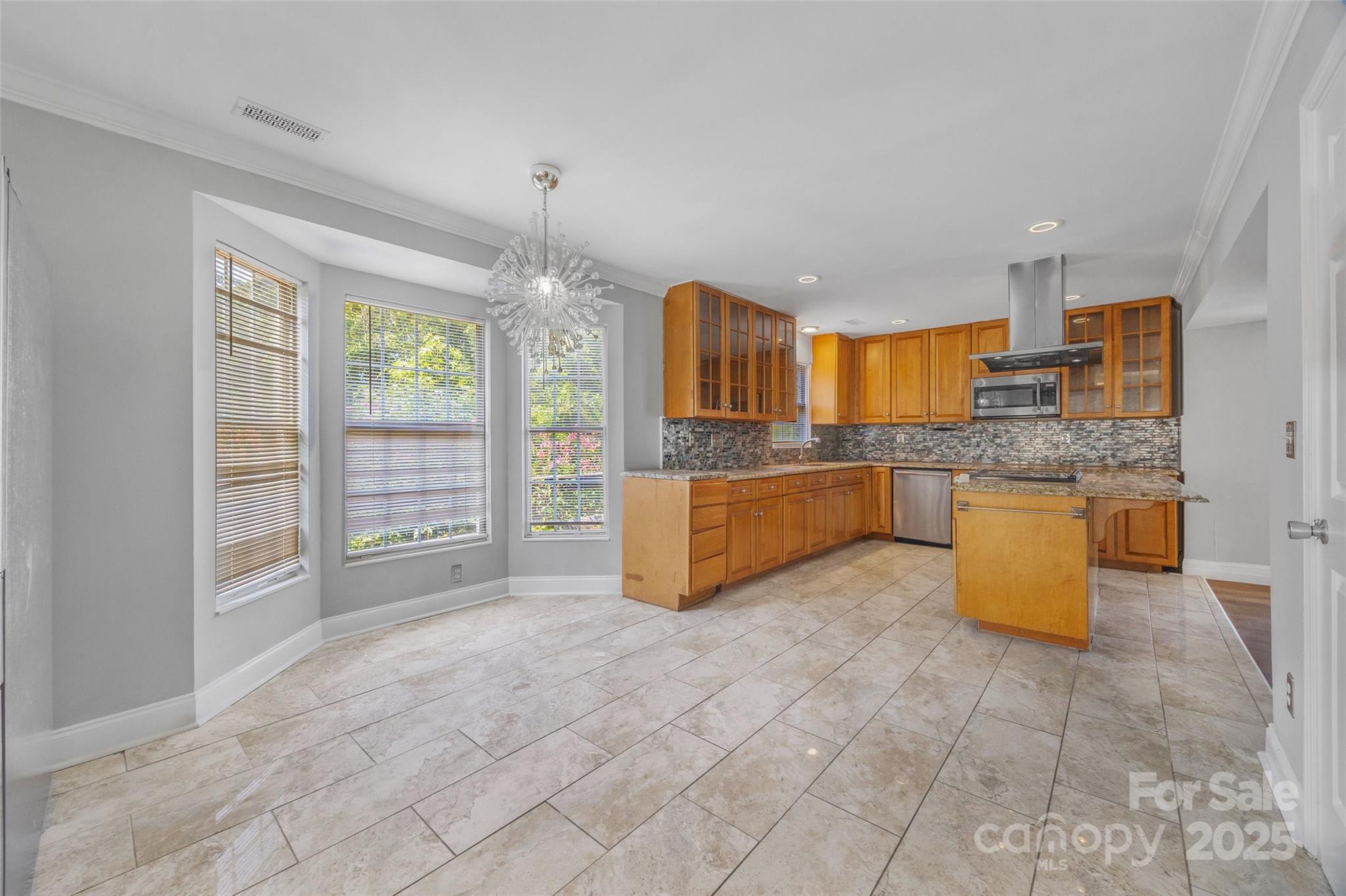 12662 Woodside Falls Road Pineville, NC 28134 - Photo 12 of 47 a large kitchen with granite countertop a stove a sink a counter space and cabinets