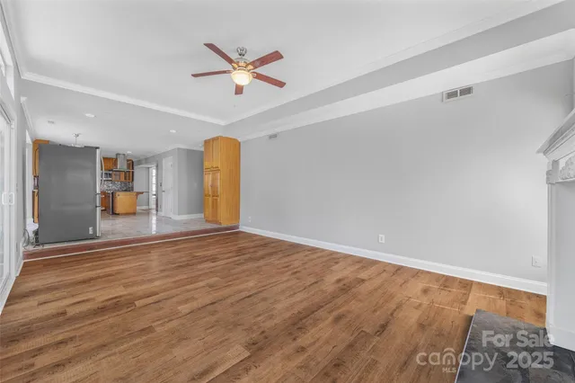 a view of empty room with wooden floor and fireplace