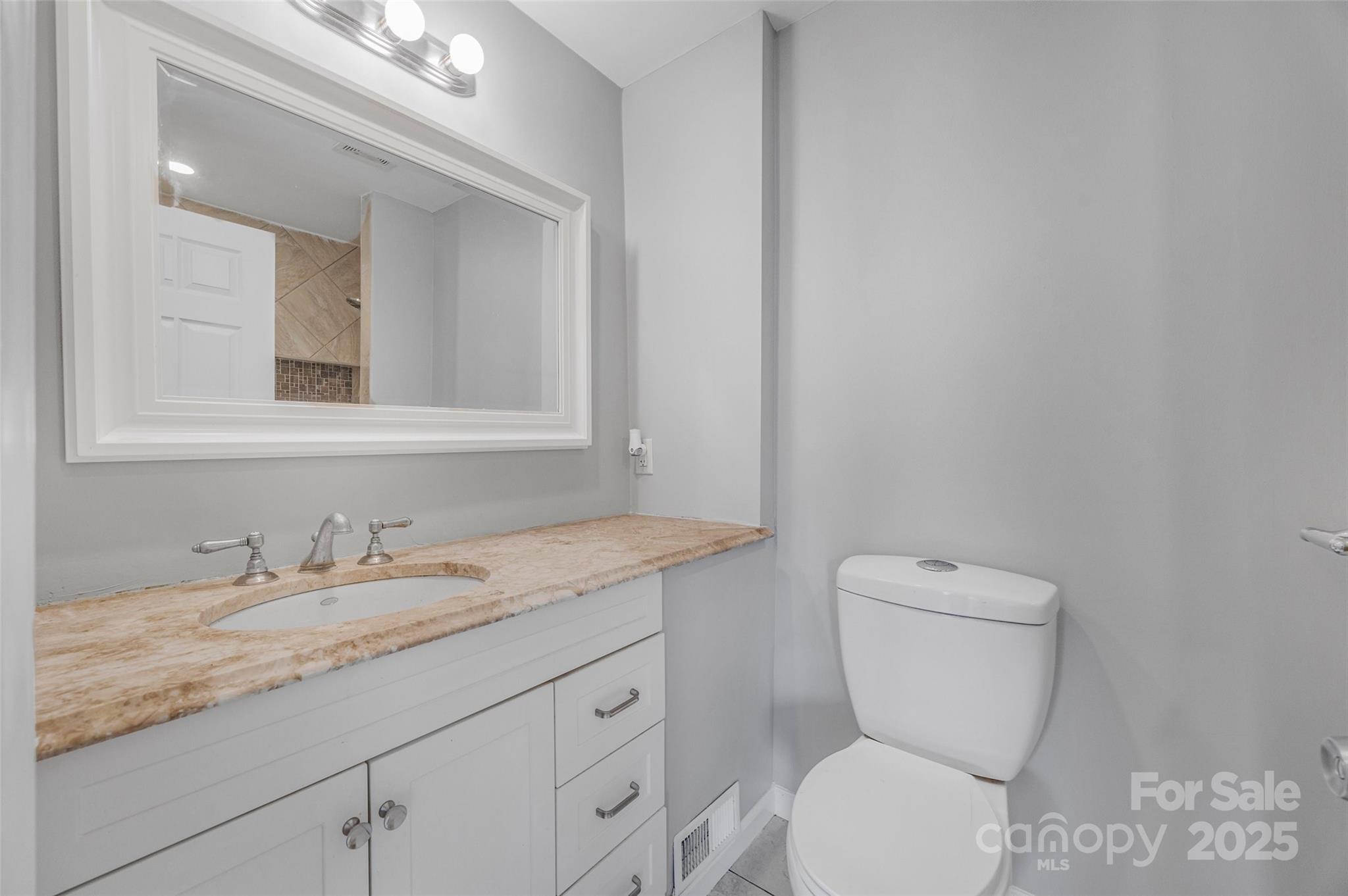 12662 Woodside Falls Road Pineville, NC 28134 - Photo 22 of 47 a bathroom with a granite countertop toilet sink and mirror
