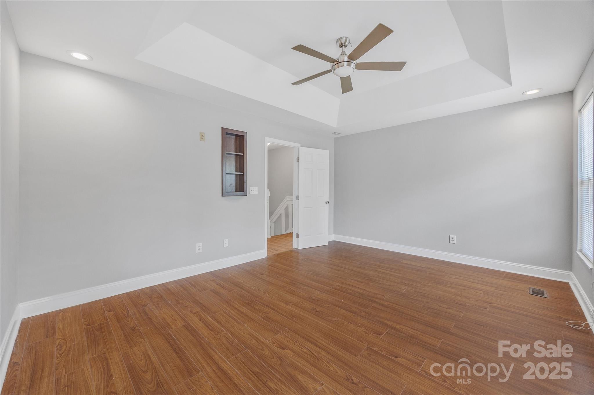 12662 Woodside Falls Road Pineville, NC 28134 - Photo 29 of 47 an empty room with wooden floor and ceiling fan
