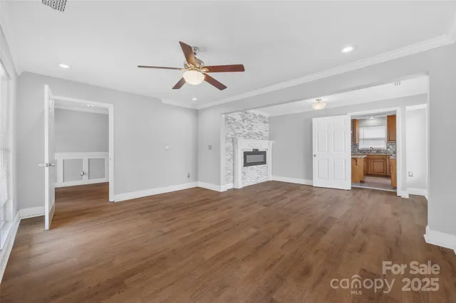 a view of empty room with wooden floor and fireplace