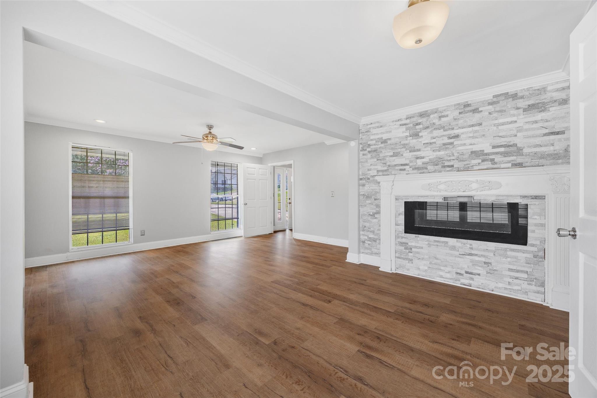 12662 Woodside Falls Road Pineville, NC 28134 - Photo 6 of 47 a view of empty room with wooden floor and fireplace