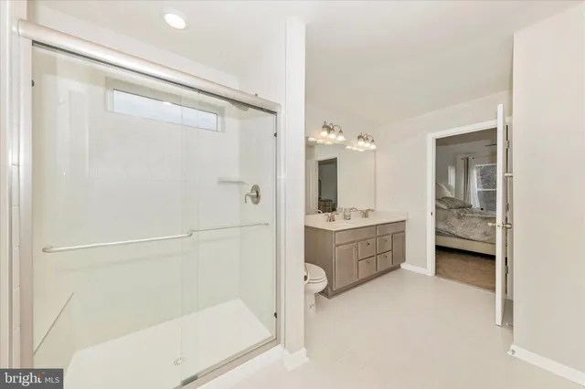 a bathroom with a double vanity sink toilet mirror and bathtub