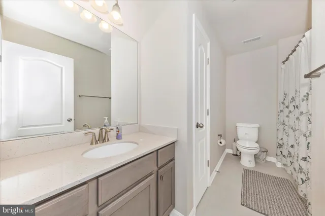 a bathroom with a sink toilet double vanity and shower
