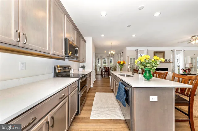 a kitchen with stainless steel appliances granite countertop a sink a stove top oven a counter space and cabinets