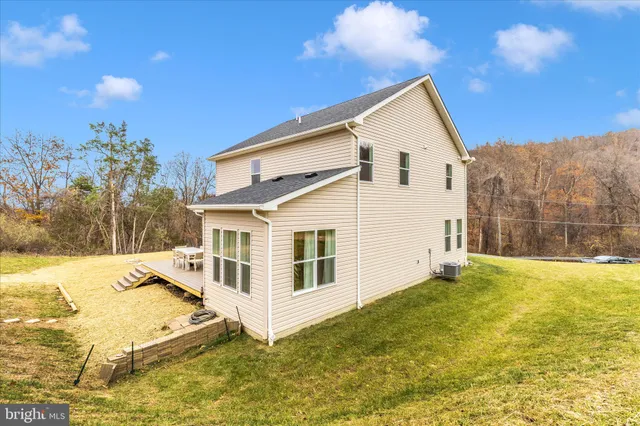 a view of a white house with a yard and sitting area