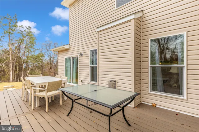 a view of a dinning table and chairs in patio of the house