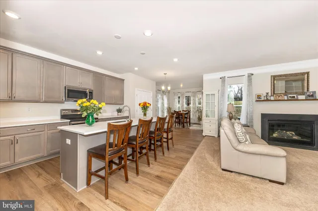 a living room with furniture a fireplace and a kitchen view