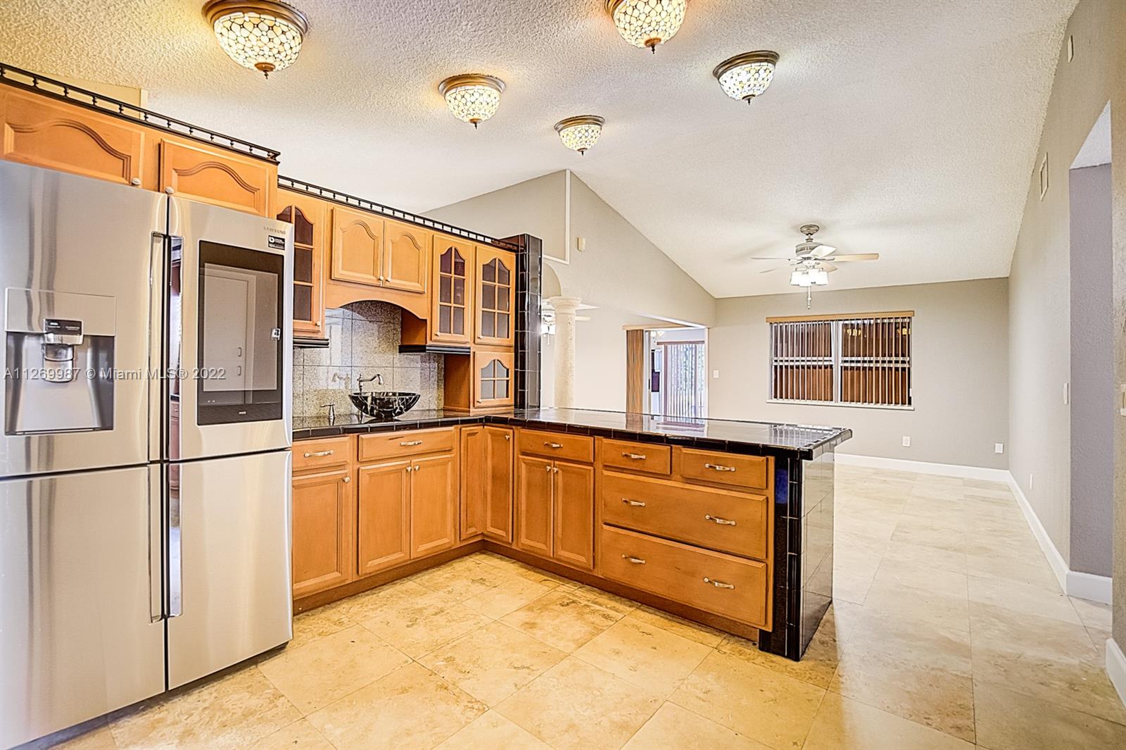 15540 Southwest 156th Avenue Miami, FL 33187 - Photo 18 of 37 a kitchen with stainless steel appliances granite countertop a sink and cabinets