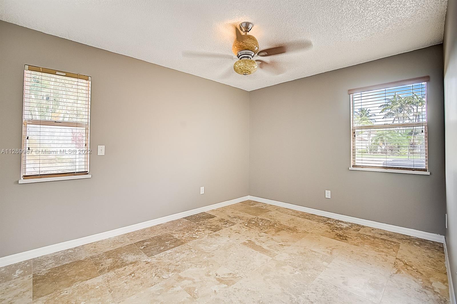 15540 Southwest 156th Avenue Miami, FL 33187 - Photo 23 of 37 a view of a big room with windows and chandelier fan