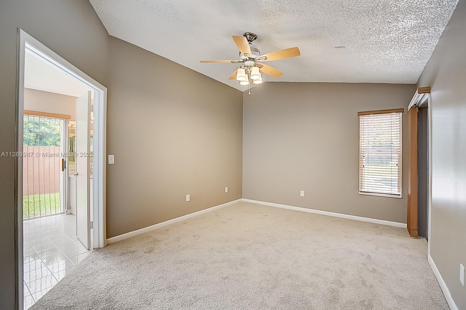 15540 Southwest 156th Avenue Miami, FL 33187 - Photo 32 of 37 an empty room that has a chandelier fan and windows