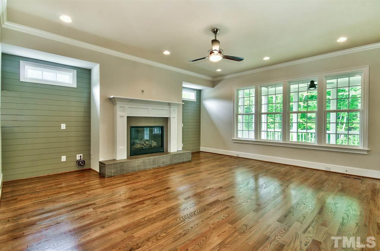 116 Roseroot Court Holly Springs, NC 27540 - Photo 5 of 25 Wide Family Room can accommodate large gatherings with ease. Transom windows flank the fireplace to allow additional natural light without sacrificing privacy.
