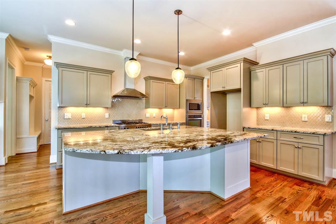 116 Roseroot Court Holly Springs, NC 27540 - Photo 6 of 25 Impressive chef's kitchen with commercial style Bertazzoni range, double ovens, vogue cabinetry and finishes and a massive center island with plenty of room for bar seating.