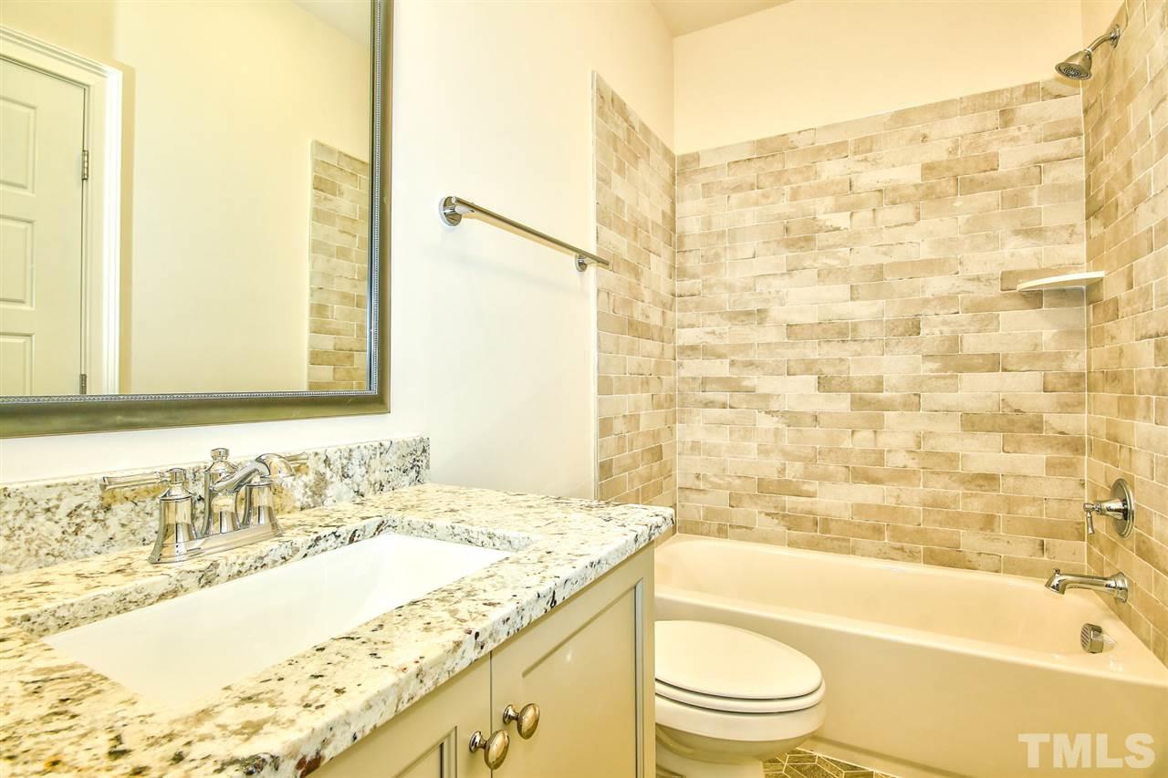 116 Roseroot Court Holly Springs, NC 27540 - Photo 10 of 25 Secondary baths are well equipped with beautiful tile, cabinetry and countertops.
