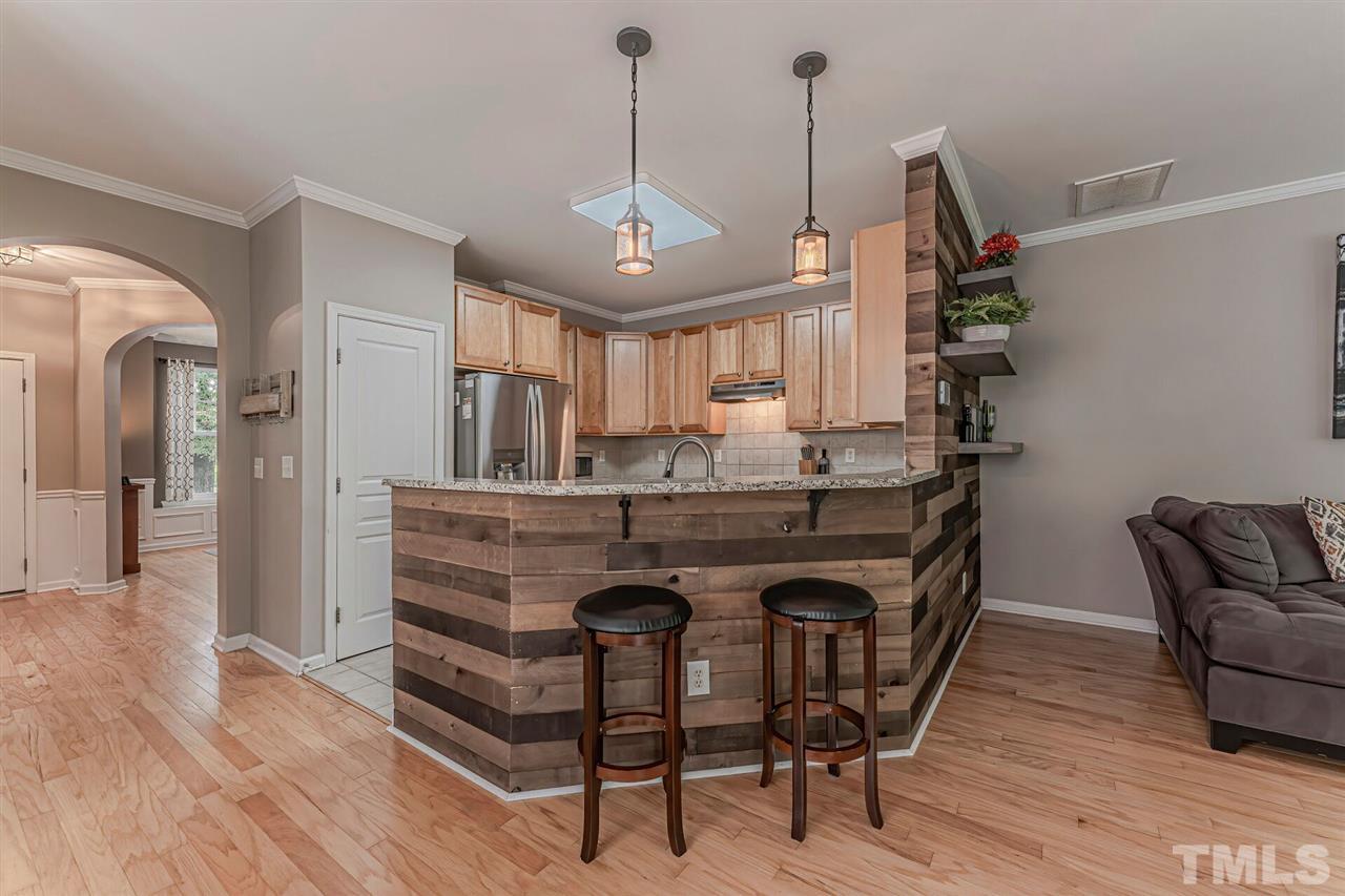 5903 Hourglass Court Raleigh, NC 27612 - Photo 11 of 29 a view of kitchen island with furniture and wooden floor
