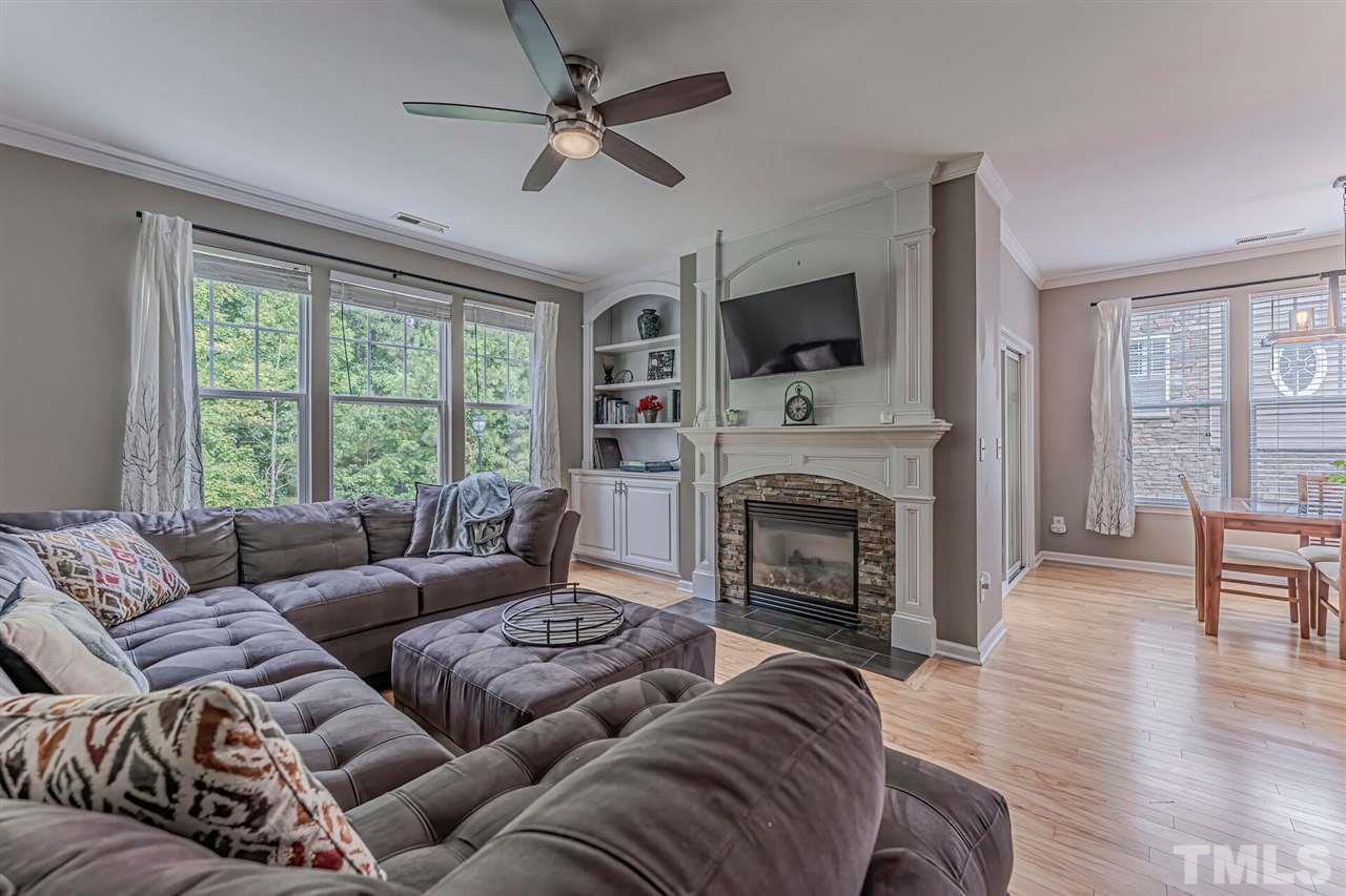 5903 Hourglass Court Raleigh, NC 27612 - Photo 16 of 29 a living room with furniture a fireplace and a flat screen tv