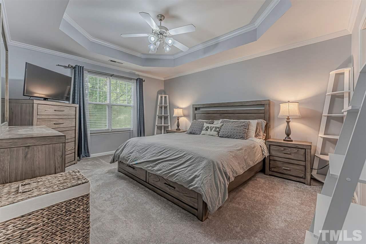 5903 Hourglass Court Raleigh, NC 27612 - Photo 19 of 29 a bedroom with a large bed and a flat screen tv