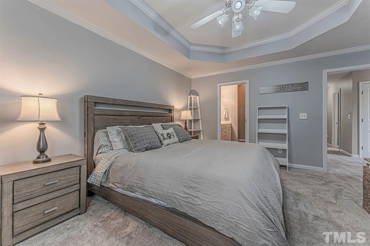 5903 Hourglass Court Raleigh, NC 27612 - Photo 20 of 29 a bedroom with a bed and a chandelier