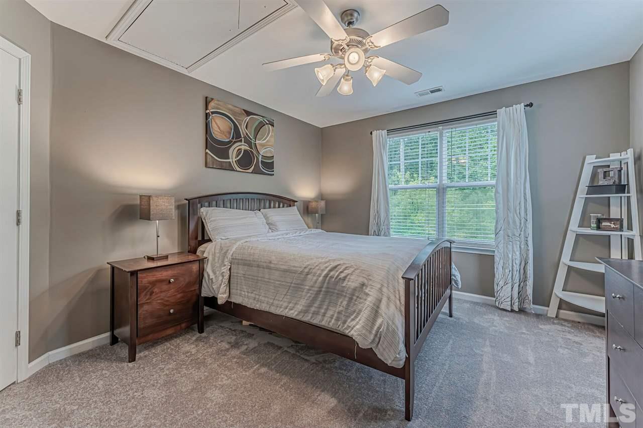 5903 Hourglass Court Raleigh, NC 27612 - Photo 24 of 29 a bedroom with a bed and a book shelf
