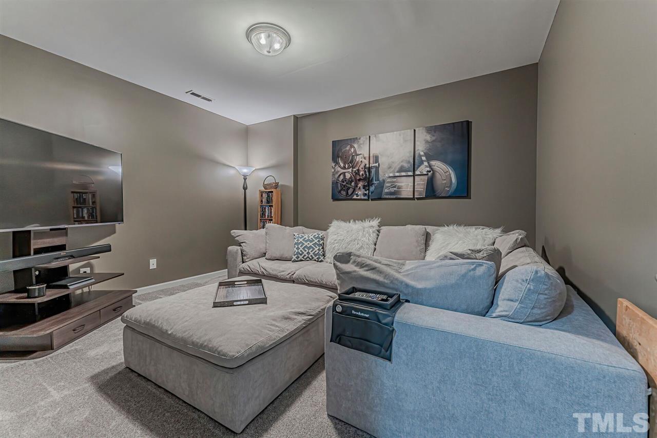 5903 Hourglass Court Raleigh, NC 27612 - Photo 26 of 29 a living room with furniture and a flat screen tv