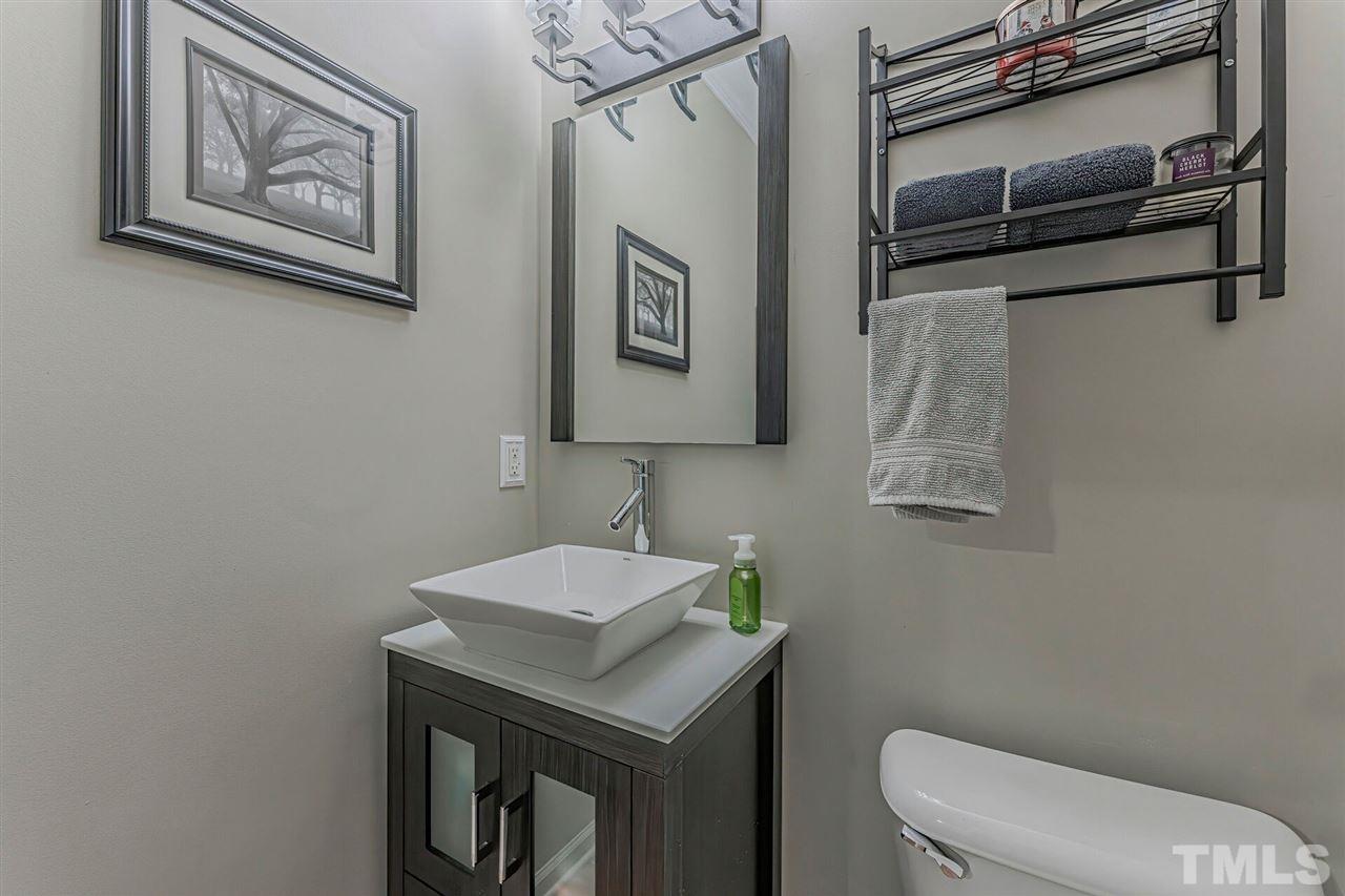 5903 Hourglass Court Raleigh, NC 27612 - Photo 7 of 29 a bathroom with a toilet a sink and mirror