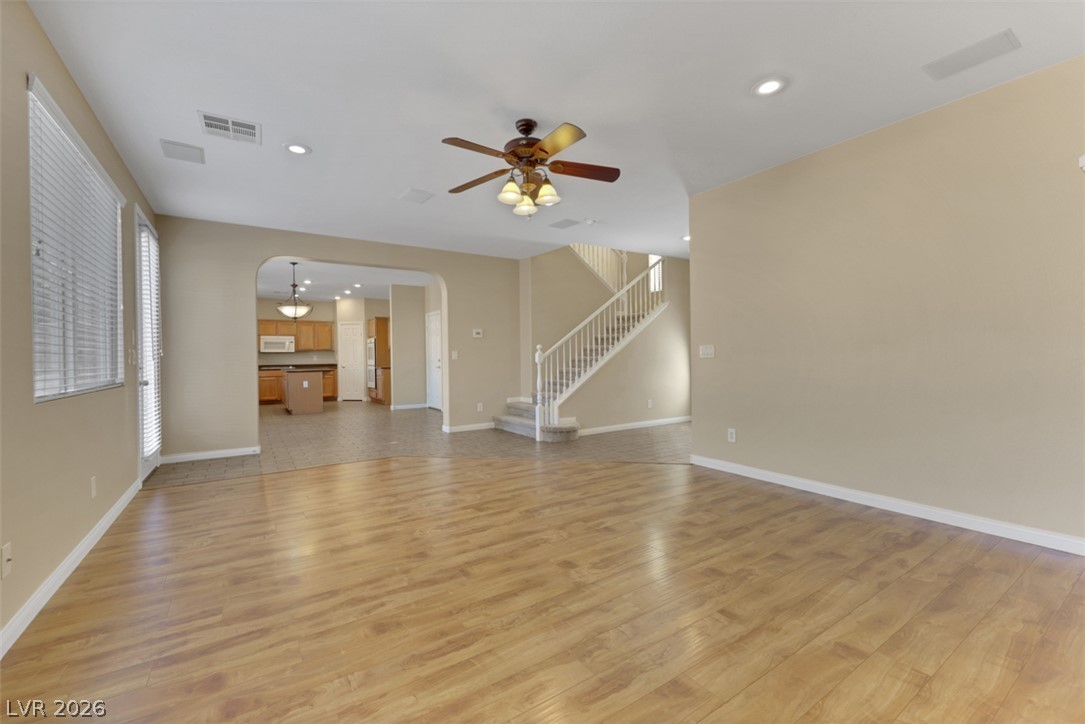 10328 Hawk Ravine Street Las Vegas, NV 89178 - Photo 8 of 55 A well-lit interior space with varied flooring leads to an inviting kitchen and elegant staircase.