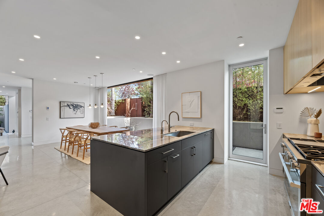 1601 Shell Avenue Venice, CA 90291 - Photo 19 of 61 a spacious kitchen with kitchen island granite countertop a sink and a stove top oven with wooden floor