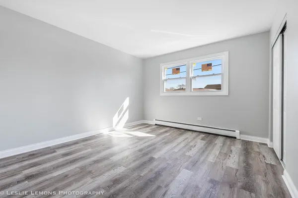 an empty room with wooden floor and window