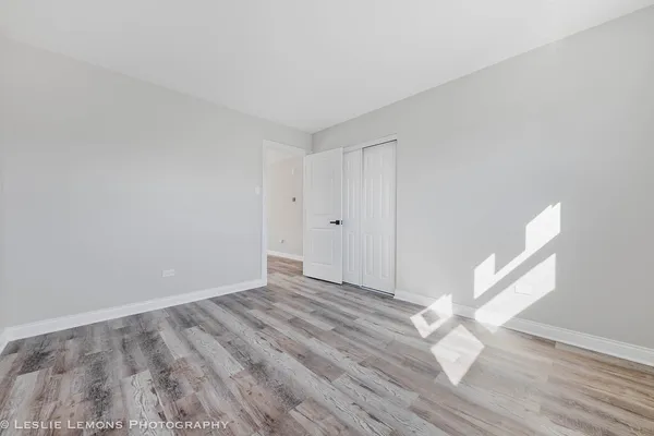 a view of empty room with wooden floor