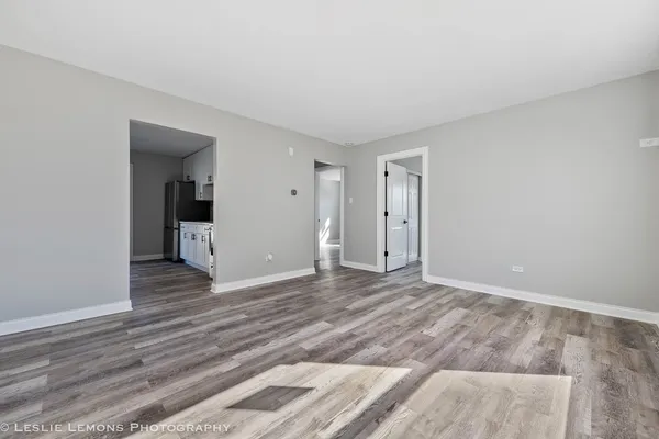 a view of a livingroom with wooden floor and a hallway