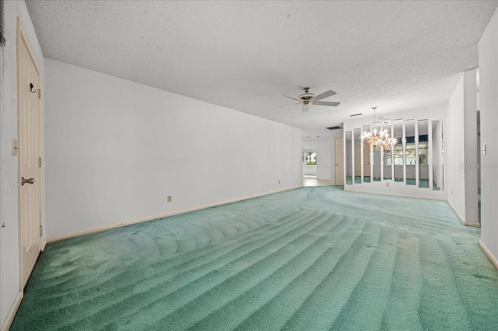 9377 Southwest 90th Court, Unit E Ocala, FL 34481 - Photo 12 of 77 a view of a livingroom with wooden floor and a ceiling fan