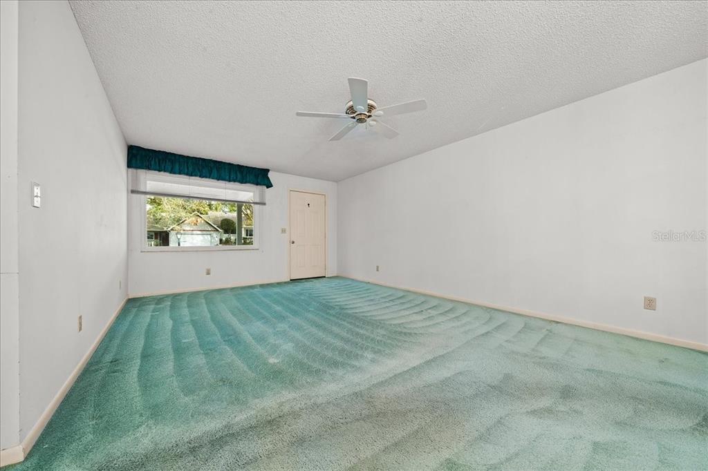 9377 Southwest 90th Court, Unit E Ocala, FL 34481 - Photo 13 of 77 an empty room with windows and ceiling fan