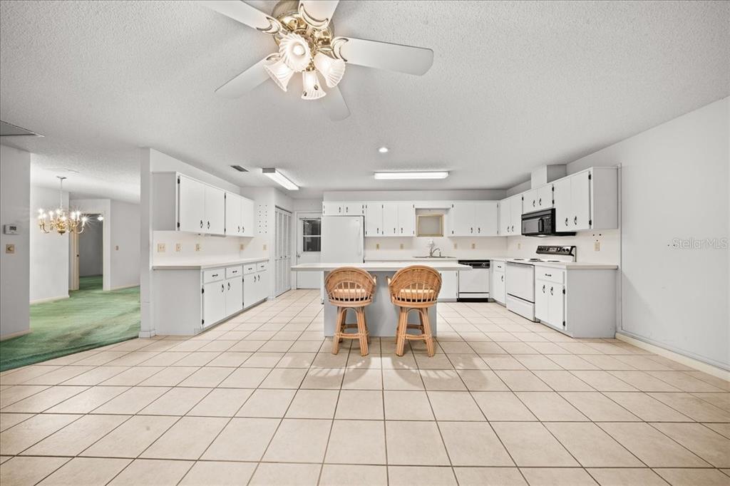 9377 Southwest 90th Court, Unit E Ocala, FL 34481 - Photo 18 of 77 a kitchen with stainless steel appliances kitchen island granite countertop a sink and cabinets