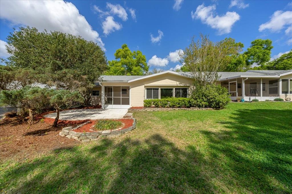 9377 Southwest 90th Court, Unit E Ocala, FL 34481 - Photo 52 of 77 a view of a house with pool and a yard