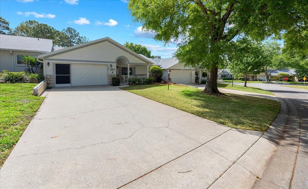 9377 Southwest 90th Court, Unit E Ocala, FL 34481 - Photo 6 of 77 a front view of a house with a yard and trees