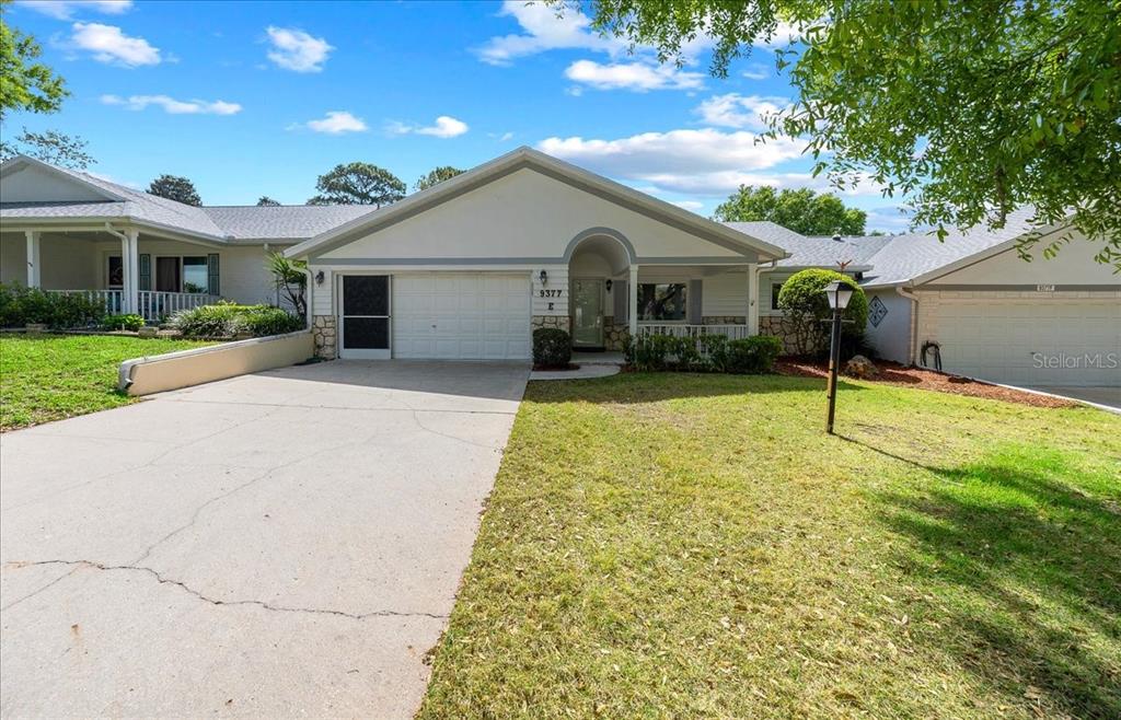 9377 Southwest 90th Court, Unit E Ocala, FL 34481 - Photo 7 of 77 a view of a house with a yard and potted plants