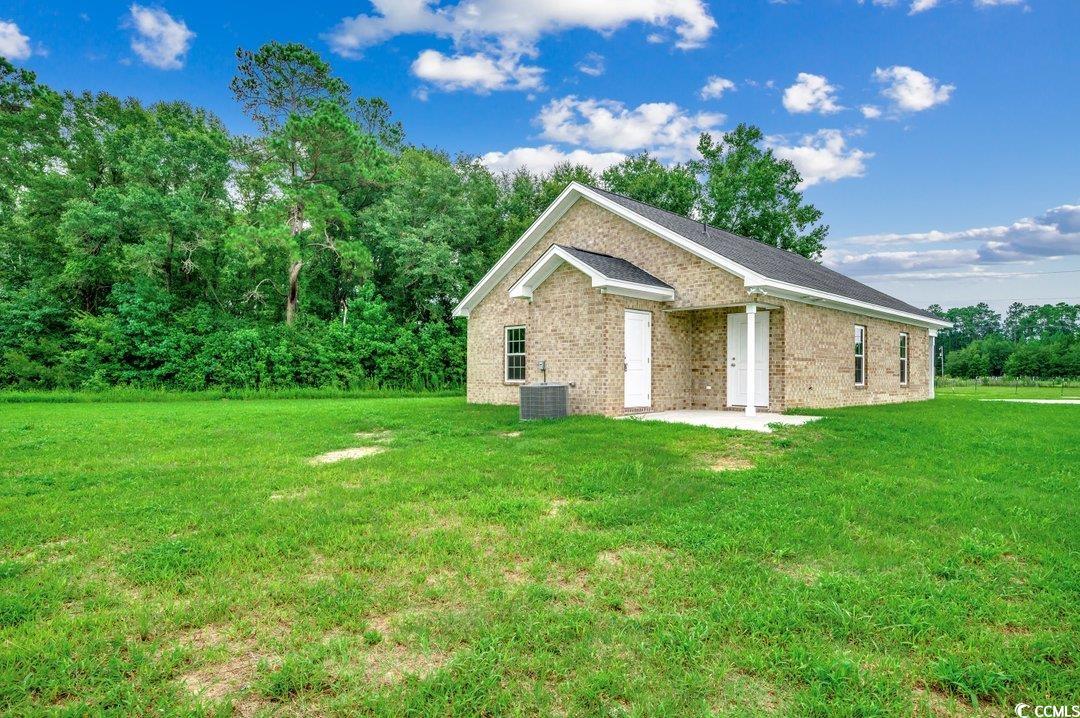 4911 Joyner Swamp Road Galivants Ferry, SC 29544 - Photo 25 of 28 View of property exterior with a lawn and central AC unit