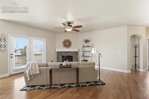a living room with furniture floor to ceiling window and a fireplace