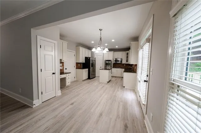 a open kitchen with white cabinets and stainless steel appliances