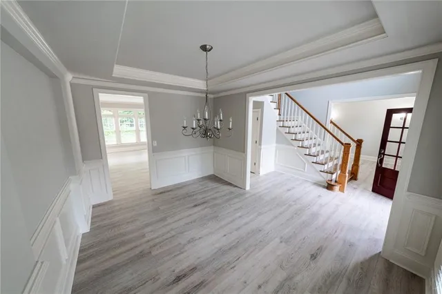 a view of a hallway with wooden floor and stairs