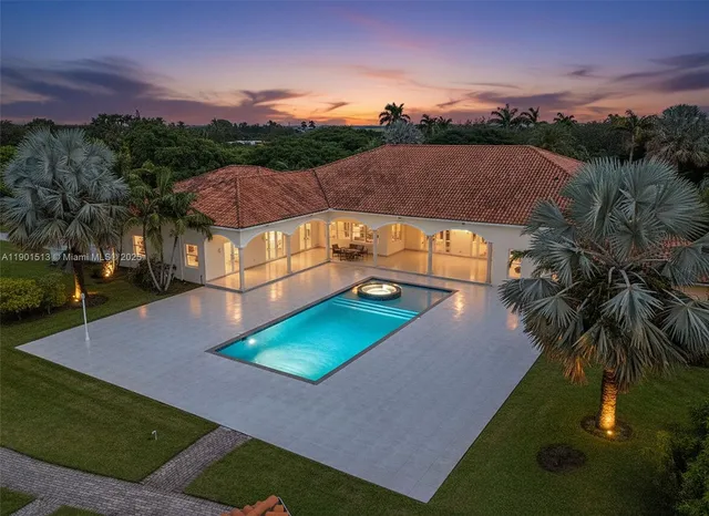 an aerial view of residential houses with outdoor space and trees