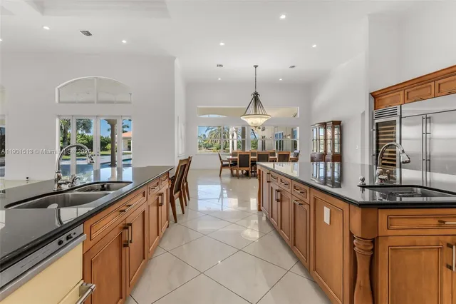 a kitchen with a sink and chairs